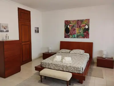 a bedroom with a bed and a painting on the wall at Cozy studio in Quarteira in Quarteira