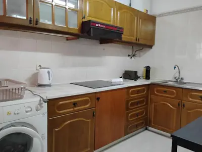 a kitchen with a washing machine and a washer at Cozy studio in Quarteira in Quarteira