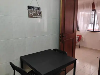 a black table with chairs and a sign on the wall at Cozy studio in Quarteira in Quarteira