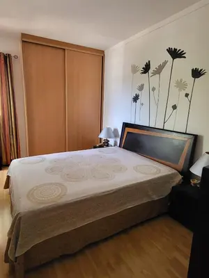 a bedroom with a large bed with flowers on the wall at MiraMar Residence in Quarteira