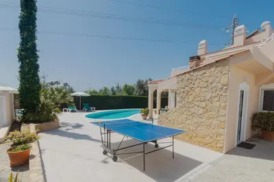 a ping pong table in the courtyard of a villa at Villa Juliet in Boliqueime