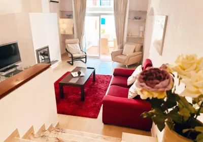 a living room with a red couch and a red rug at Windmill Hill Apartment in Albufeira