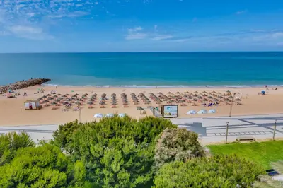 an aerial view of a beach with umbrellas and the ocean at Carteia Beachfront at Praia da Gaivota in Quarteira