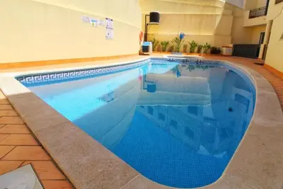 a large swimming pool with blue water in a building at Boa Vista Apartment with Sea Views and Shared Pool in Albufeira