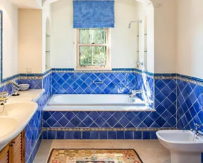 a blue tiled bathroom with a tub and a sink at Traditional property with pool nice large garden in FAO
