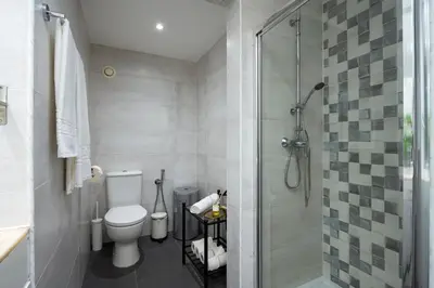 a bathroom with a toilet and a glass shower at Vilamoura Marine Prestige in Quarteira