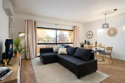 a living room with a black couch and a table at Vilamoura Marine Prestige in Quarteira
