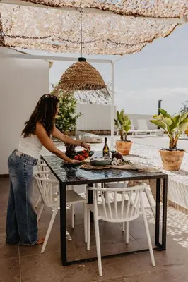 a woman preparing food on a table on a patio at Luzico ALGARVE in Loulé