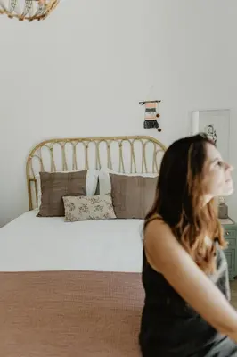 a woman sitting on the floor in front of a bed at Luzico ALGARVE in Loulé