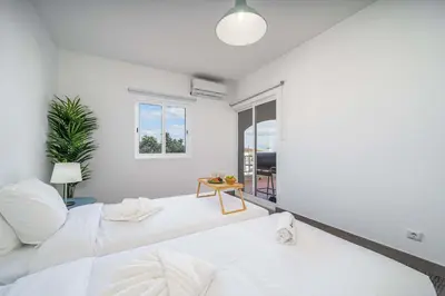 a white room with a bed and a table at Panoramic Sea Views & Balcony BBQ by HostWise in Albufeira