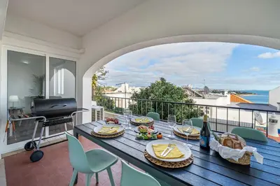 a table with food on top of a balcony at Panoramic Sea Views & Balcony BBQ by HostWise in Albufeira