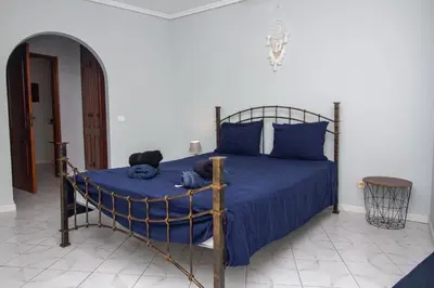 a bedroom with a bed with blue sheets and blue pillows at Top Strip Albufeira in Albufeira