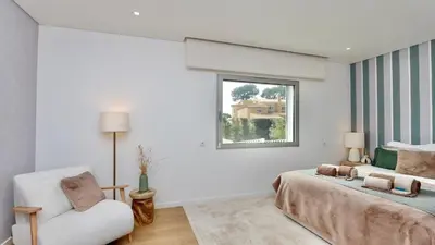 a bedroom with a bed and a chair and a window at Villa Barinel by Cleverdetails located in a quiet and privileged area of Vilamoura in Quarteira