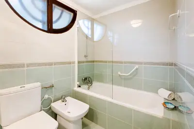 a bathroom with a toilet and a tub and a sink at Villa Ipanema Poolside Living by LovelyStay in Quarteira