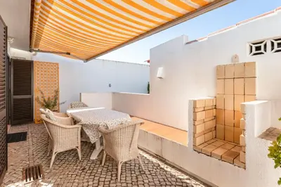 an outdoor patio with a table and chairs at Villa Ipanema Poolside Living by LovelyStay in Quarteira