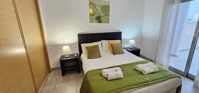 a bedroom with a bed with two pillows on it at Vitismar II com piscina, jardim e garagem in Guia