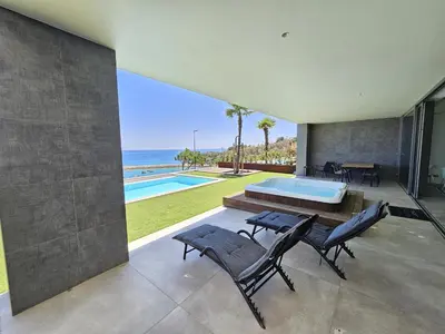a house with a view of a swimming pool and the ocean at Finisterra Deluxe in Albufeira