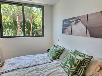a bedroom with a bed with pillows and a window at Finisterra Deluxe in Albufeira