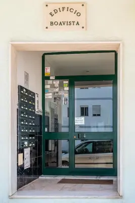 an entrance to a building with a green door at Apartamento Norte by Férias com Sol in Quarteira