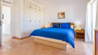 a bedroom with a large bed with blue sheets at Greice Homes - Villa Vieira in Quarteira