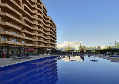 a swimming pool in front of a large building at Dom Pedro Portobelo in Quarteira