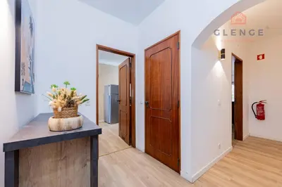 a hallway with a door and a table with a plant at Torre Mira Praia 2 Quartos by Glenge Holiday in Loulé
