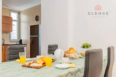 a dining room table with orange juice and food on it at Torre Mira Praia 2 Quartos by Glenge Holiday in Loulé