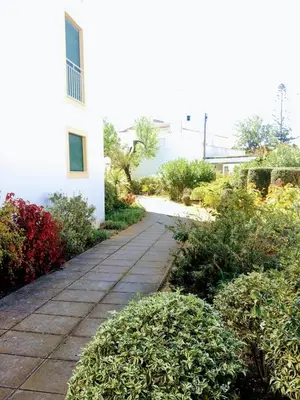 a walkway next to a white building with bushes at C Dreams - Comfortable and luminous apartment in Albufeira