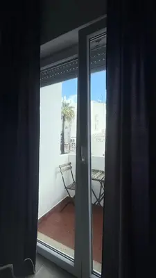 a room with curtains and a door with a mirror at My Cozy Oura Studio in Albufeira