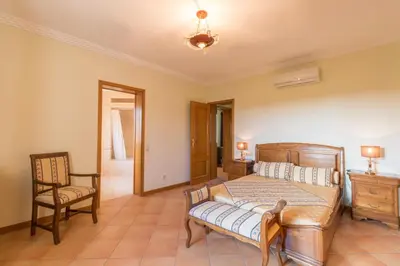 a bedroom with a bed and a desk and a chair at Vivenda Alegria in Albufeira