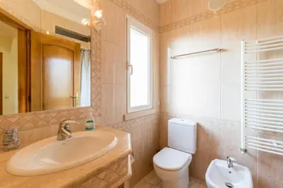 a bathroom with a sink and a toilet and a mirror at Vivenda Alegria in Albufeira