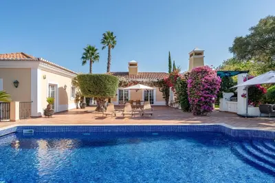 a swimming pool in front of a house at Villa Serena in Almancil