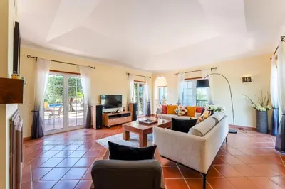 a living room with two couches and a tv at Villa Serena in Almancil