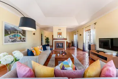 a living room with a couch and a tv at Villa Serena in Almancil
