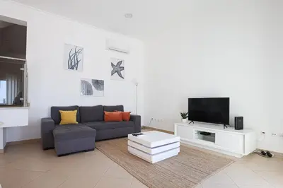 a living room with a couch and a tv at Casa Ferreira - Encosta Vista Salgados - BY BEDZY in Guia