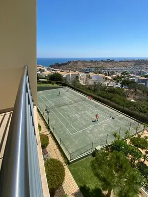 two people playing tennis on a tennis court at E Orada sea view historic center tennis in Albufeira