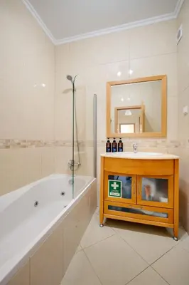 a bathroom with a tub and a sink and a mirror at E Orada sea view historic center tennis in Albufeira