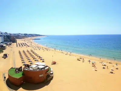 a beach with a lot of people and the ocean at E Orada sea view historic center tennis in Albufeira
