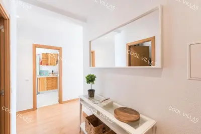 a white bathroom with a mirror and a table at Apartamento Laurent - beachfront and city center in Albufeira