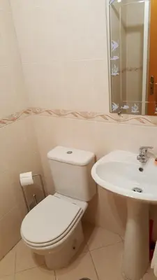 a white bathroom with a toilet and a sink at Albufeira - T2 Old Town Central - 200m Beach in Albufeira