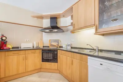a kitchen with wooden cabinets and a sink at Apartamentos Valverde - Quinta do Lago in Quinta do Lago