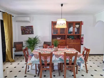a dining room with a table and chairs at Casa das Flores in Albufeira