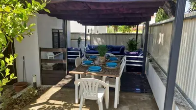 a patio with a table and chairs under a purple canopy at Casa das Flores in Albufeira