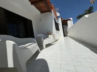 a walkway with white chairs on a building at Casa das Flores in Albufeira