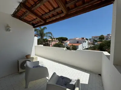 a balcony with chairs and a view of a city at Casa das Flores in Albufeira