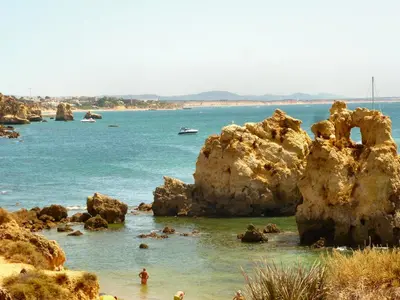 a beach with some rocks in the water at Casa das Flores in Albufeira
