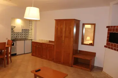 a kitchen with a wooden cabinet and a mirror at Cheerfulway Minichoro Apartamentos in Albufeira