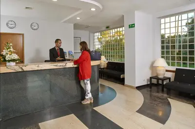 a woman standing at a counter in an office at Cheerfulway Minichoro Apartamentos in Albufeira