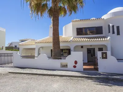 a white house with a palm tree in front of it at Villa Galé 600m from the beach by Interhome in Patroves