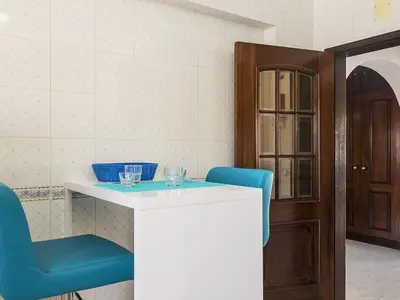 a dining room with a table and a blue chair at Villa Galé 600m from the beach by Interhome in Patroves